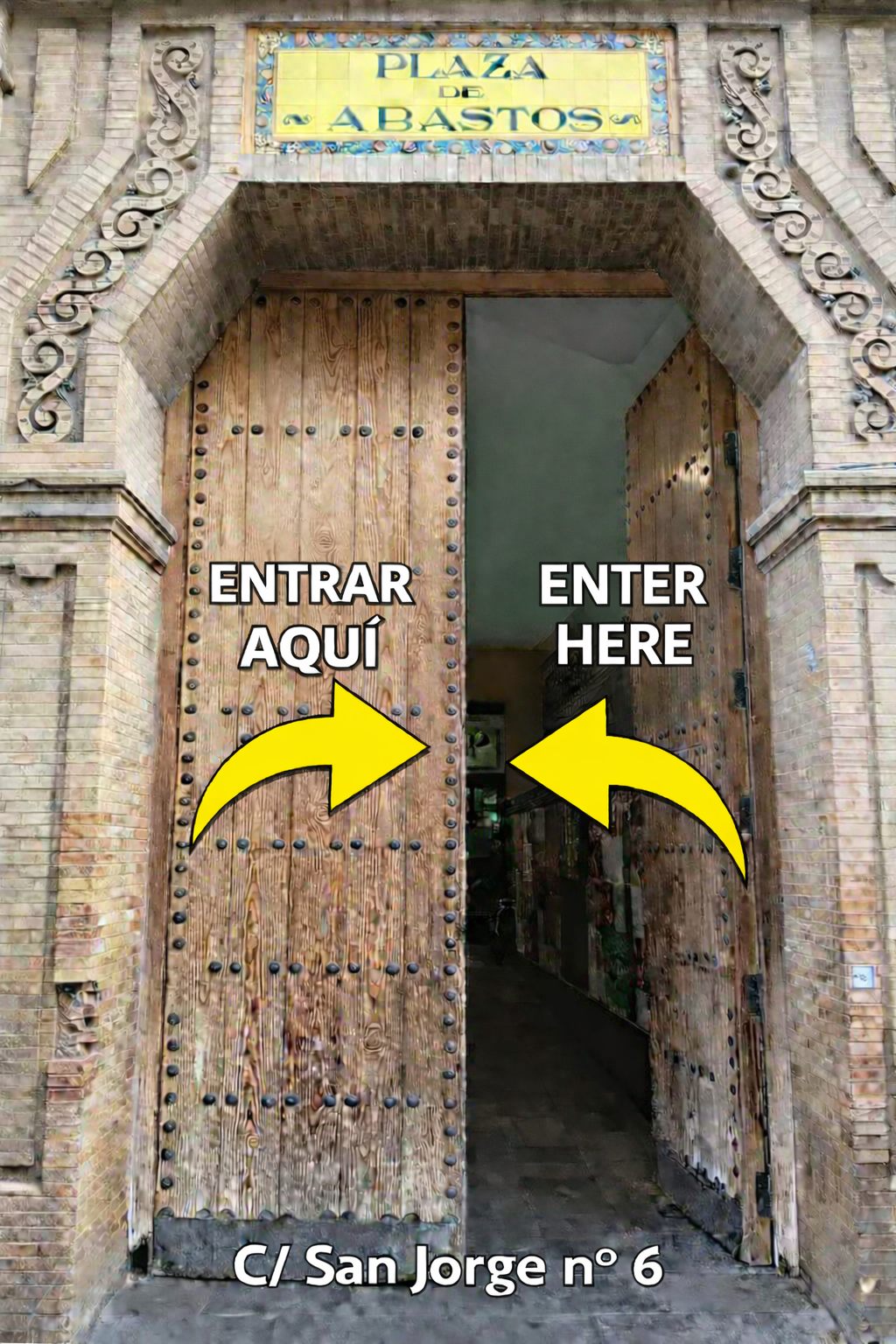 Puertas del Mercado de Triana en Calle San Jorge nº 6, con flechas que indican la entrada al teatro